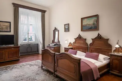 a bedroom with a bed and two windows and a bed sidx sidx sidx at Grand Hotel Praha in Prague