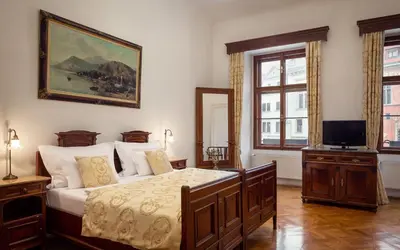 a bedroom with a bed and a television in it at Grand Hotel Praha in Prague