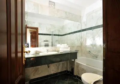 a bedroom with a bed and a table with a vase on it at Grand Hotel Praha in Prague
