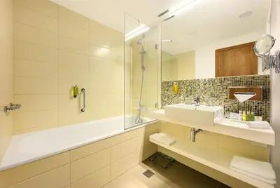 a bathroom with a tub and a sink and a shower at Hotel Duo & Wellness in Prague