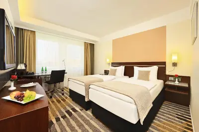 a hotel room with a large bed and a desk at Hotel Duo & Wellness in Prague