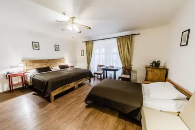 a bedroom with two beds and a table at Archibald At the Charles Bridge in Prague