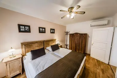 a bedroom with a bed and a ceiling fan at Archibald At the Charles Bridge in Prague