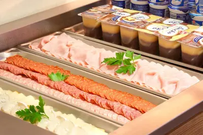 two trays of meat and carrots in a refrigerator at Akcent hotel in Prague
