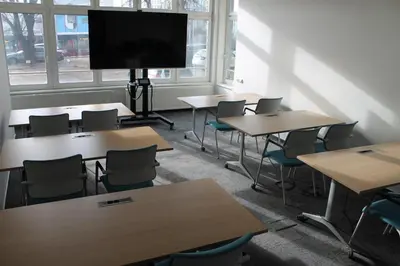 a classroom with tables and chairs and a flat screen tv at Akcent hotel in Prague