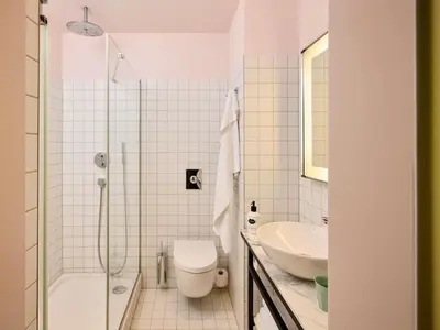 a white bathroom with a toilet and a sink at Mama Shelter Prague in Prague