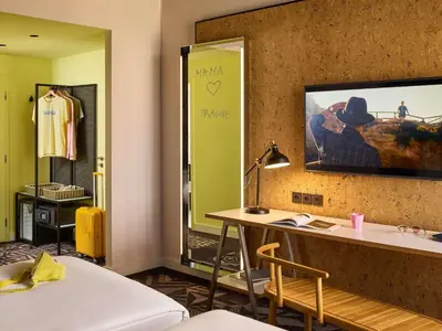 a room with a desk and a tv on a wall at Mama Shelter Prague in Prague