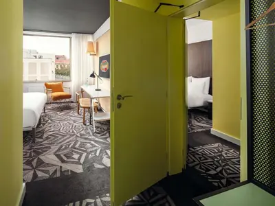 a hotel room with a green door and a bedroom at Mama Shelter Prague in Prague