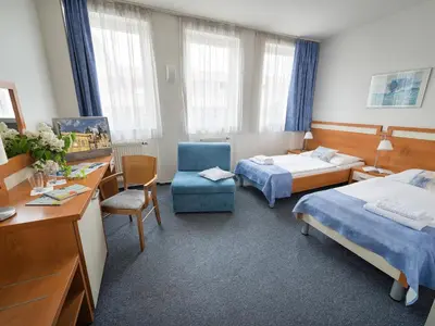 a hotel room with two beds and a chair at EA Hotel Populus in Prague