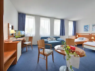 a hotel room with a living room with a couch and a table at EA Hotel Populus in Prague