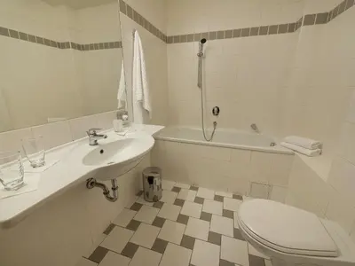 a bathroom with a sink and a toilet and a tub at EA Hotel Populus in Prague