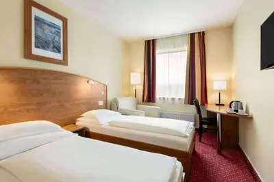 a hotel room with two beds and a desk at Amedia Express Prague, Trademark Collection by Wyndham in Prague