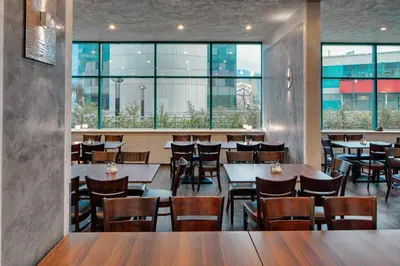 a restaurant with tables and chairs and windows at Amedia Express Prague, Trademark Collection by Wyndham in Prague