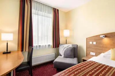 a hotel room with a bed and a desk and a chair at Amedia Express Prague, Trademark Collection by Wyndham in Prague