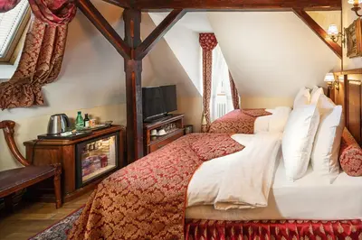 a bedroom with a bed with red and white sheets at Hotel U Prince Prague by BHG in Prague