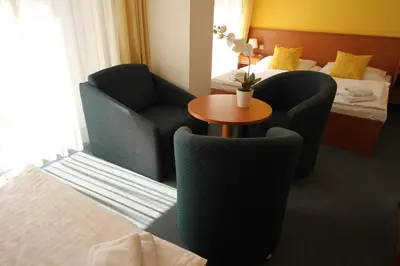 a hotel room with two chairs and a table and a bed at Hotel Meritum in Prague