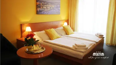 a hotel room with a bed and a table at Hotel Meritum in Prague