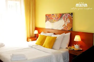 a hotel room with a bed with yellow pillows at Hotel Meritum in Prague
