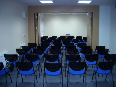 a room with chairs and a white screen and a classroom at Hotel Meritum in Prague