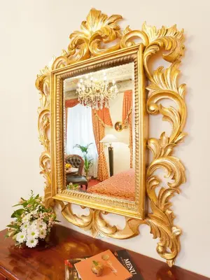 an ornate gold mirror on a wall at Hotel U Zlatého Stromu Prague by BHG in Prague
