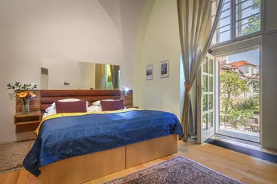 a bedroom with a bed and a large window at Monastery Hotel in Prague