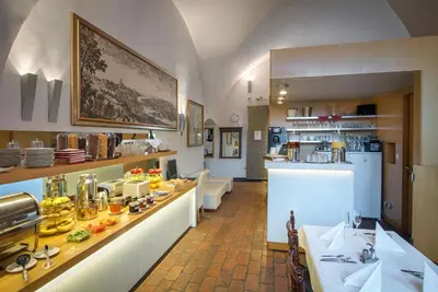 a bedroom with a bed and a large window at Monastery Hotel in Prague