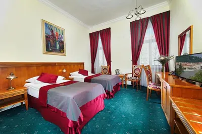 a hotel room with two beds and a flat screen tv at Green Garden Hotel in Prague
