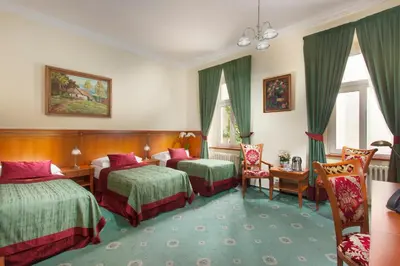 a hotel room with two beds and two chairs at Green Garden Hotel in Prague