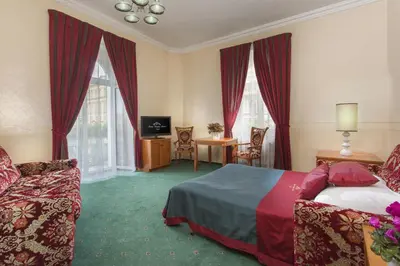 a hotel room with a bed and a table and chairs at Green Garden Hotel in Prague