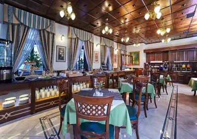 a restaurant with tables and chairs and a bar at Green Garden Hotel in Prague