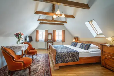 a bedroom with a bed and a table and chairs at Red Lion Hotel in Prague