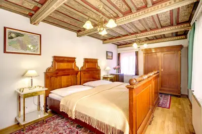 a bedroom with a large bed and a wooden ceiling at Red Lion Hotel in Prague