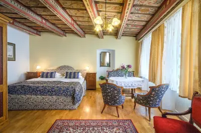 a bedroom with a bed and a table and chairs at Red Lion Hotel in Prague