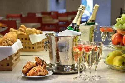 a table with glasses of champagne and bread and wine bottles at Bishop's House in Prague