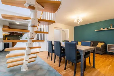 a dining room with a spiral staircase and a table and chairs at EA ApartHotel Melantrich in Prague
