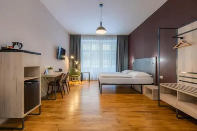 a room with a bed and a table and a kitchen at EA ApartHotel Melantrich in Prague