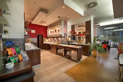 a restaurant with a counter in the middle of a room at Rezidence Emmy in Prague