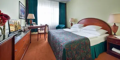 a hotel room with a large bed and a desk at Rezidence Emmy in Prague