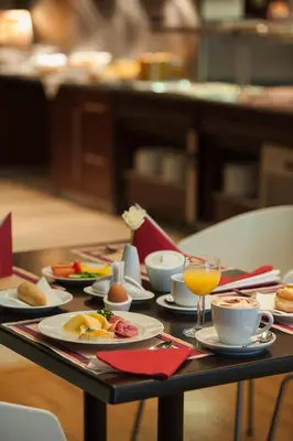 a table with plates of food and a glass of orange juice at Rezidence Emmy in Prague