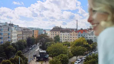 a woman looking down at a city street with buildings at Plaza Boutique Hotel - Czech Leading Hotels in Prague