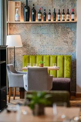 a room with a couch and a table with wine bottles at Plaza Boutique Hotel - Czech Leading Hotels in Prague