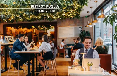 a group of people sitting at tables in a restaurant at Plaza Boutique Hotel - Czech Leading Hotels in Prague