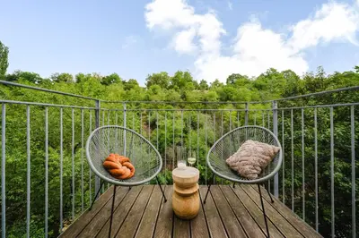 two chairs on a deck with a view of a forest at Prague Days - Two-bedroom Loft with 3 Terraces and Parking in Hip Žižkov in Prague