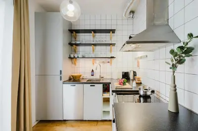 a kitchen with white appliances and a black counter top at Prague Days - Two-bedroom Loft with 3 Terraces and Parking in Hip Žižkov in Prague