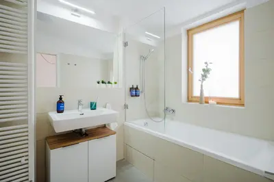 a white bathroom with a sink and a bath tub at Prague Days - Two-bedroom Loft with 3 Terraces and Parking in Hip Žižkov in Prague