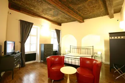 a bedroom with a bed and a table and chairs at U Tří Bubnů in Prague