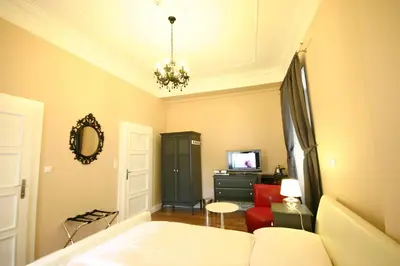 a bedroom with a bed and a couch and a tv at U Tří Bubnů in Prague