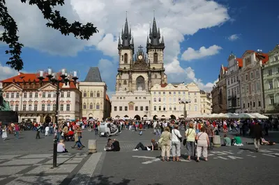 a group of people standing in front of a building with a clock tower at U Tří Bubnů in Prague