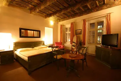 a bedroom with a bed and a table and a tv at U Tří Bubnů in Prague