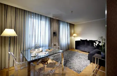a living room with a glass table and a couch at Eurostars Thalia in Prague